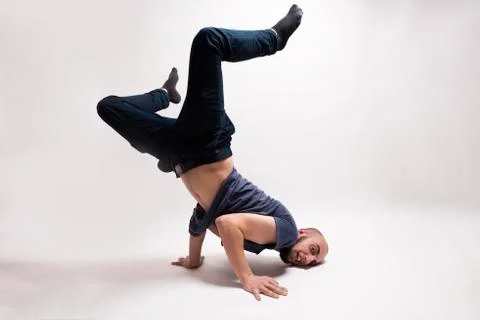 Stylish dancer doing breakdance figures. Standing on both hands, head down and Stock-Fotos