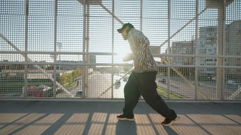 Stylish dancer male in zebra-patterned hoodie and beanie performs an energetic Stock Footage 292565292