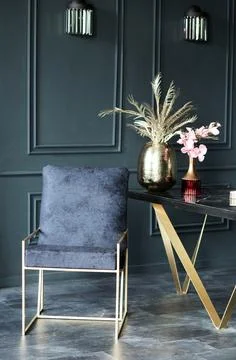 Stylish dark interior featuring a plush navy chair with gold accents beside a Stock Photos