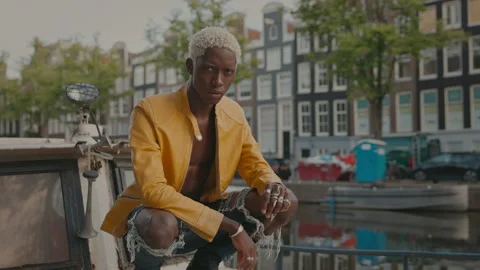 Stylish Dark Skinned Guy On Street. He Is Squatting. Video stock 210179267