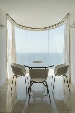 Stylish dining area with ocean view offering tranquility and elegance at sunrise Stock Photos
