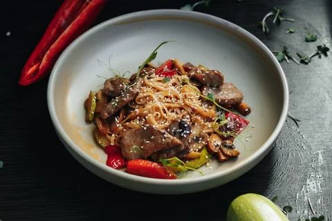 Stylish dish featuring tender beef, rice noodles, and vibrant red chili Stockfoto's