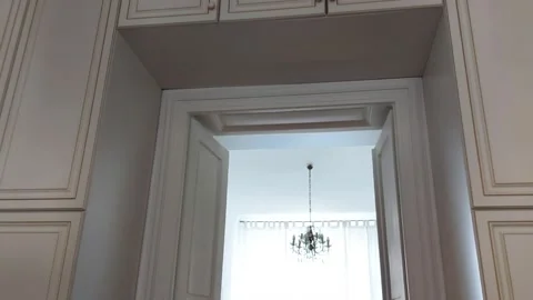 Stylish Doorway Framed by Cabinets, Light-Filled Room Beyond 스톡 동영상 319251069