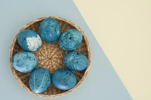 Stylish Easter background with colored eggs in a basket and place for text. Top Stock Photos