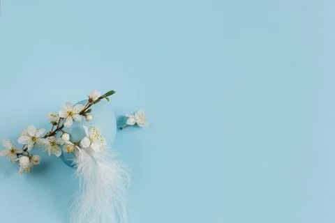 Stylish easter egg and spring blossom on blue background flat lay. Minimal .. Stock Photos