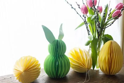 Stylish Easter eggs and Easter bunny paper honeycomb decoration on rustic t.. Stock Photos