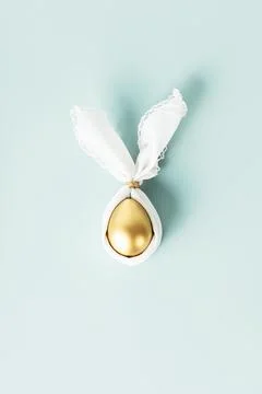 Stylish Easter flat lay with golden egg in easter bunny napkin over blue ba.. Stock Photos