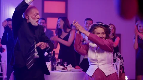 Stylish elderly couple having fun dancing at a colorful party . Stock Footage 123733150