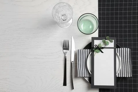 Stylish elegant table setting and blank card on wooden background, top view.  Stock Photos