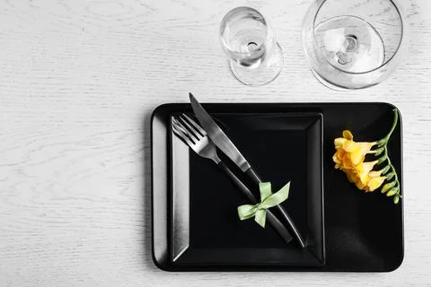Stylish elegant table setting with freesia on white wooden background, top vi Stock Photos