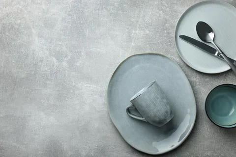 Stylish empty dishware and cutlery on light grey table, flat lay. Space for t Stock Photos