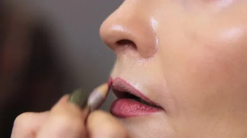 Stylish evening make-up to a beautiful young woman is done by a professional mak Stock Footage 137570837