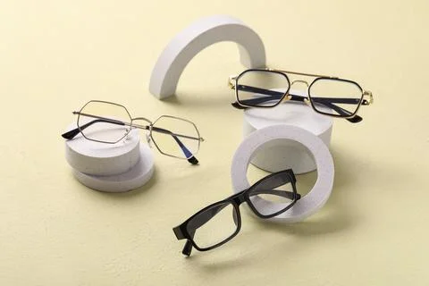 Stylish eyeglasses collection with modern frames on geometric concrete podium Stock Photos