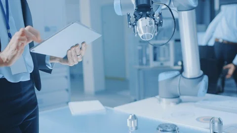 Stylish Female Industrial Robotics Engineer Uses Tablet Computer to Program Stock Footage 105366355
