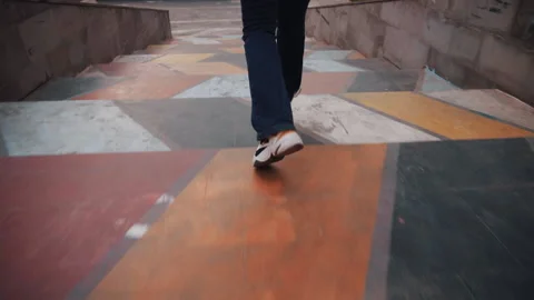 Stylish female legs running down on multi colored creative stairs in street Stock Footage 187768571