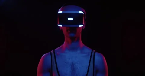 Stylish future handsome young man gamer wearing VR headset on black background Video stock 177515480