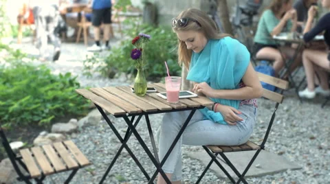 Stylish girl browsing internet on tablet and drinking fruity cocktail Stock Footage 67752745