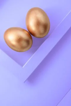 Stylish golden eggs easter concept on trendy purple background. Easter gold egg Stock Photos