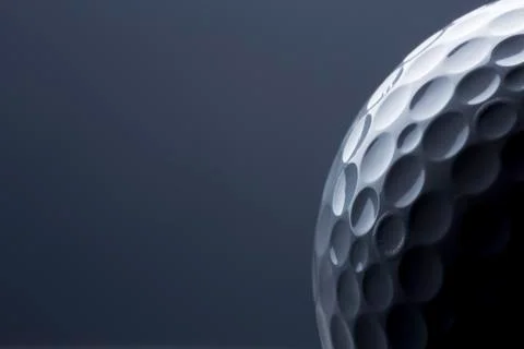 Stylish golf ball isolated on empty dark blue background. Stock Photos