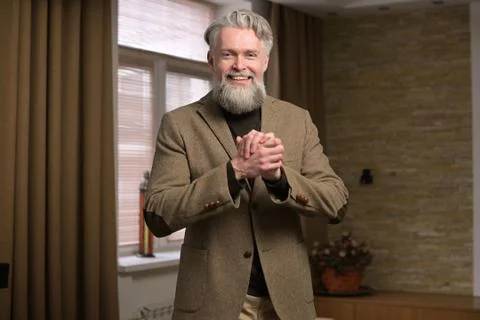 Stylish gray-haired man with a beard in a jacket looks confidently Stock Photos