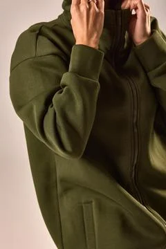 Stylish green zip-up jacket with open collar worn by person in casual fashi.. Stock Photos