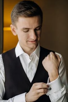 Stylish groom portrait at the window while getting ready in the Stock Photos