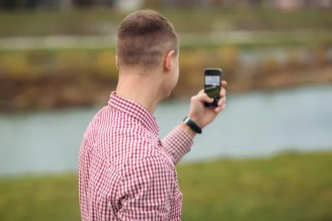 Stylish guy in a chekered shirt using a phone Stock-Fotos