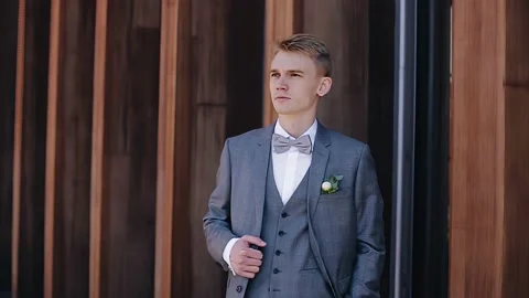 Stylish guy in a jacket stands looking to the side and then looks at the camera Stock Footage 159156976