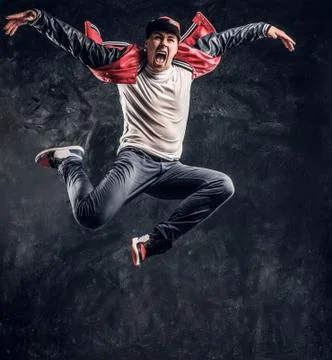 Stylish guy performs breakdance acrobatic elements. Stock Photos