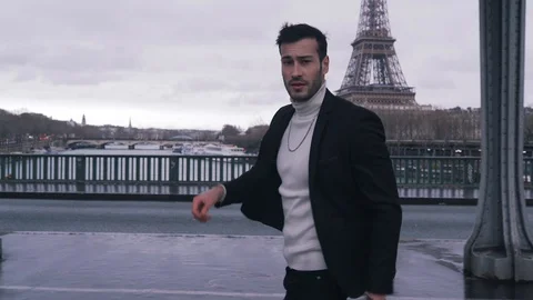 Stylish guy walking on a eiffel tower background Stock Footage 128522837