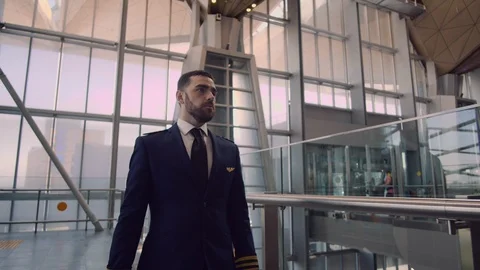 Stylish handsome bearded pilot puts on his pilot cap, corrects the uniform and Stock Footage 109148663