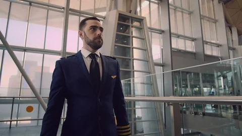 Stylish handsome bearded pilot puts on his pilot cap, corrects the uniform and Stock Footage 109148692