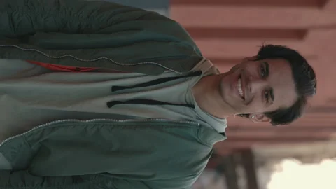 Stylish handsome guy with earrings smiling on city street Stock Footage 164035232