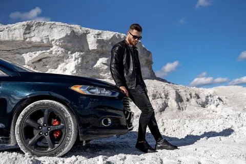 Stylish handsome man posing with car. Elegant young businessman. Stock Photos