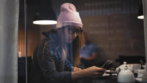 A stylish hipster female in glasses using smart watch and using app on a Stock Footage 80719387