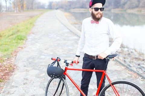 Stylish hipster guy posing with his bicycle. Stock Photos