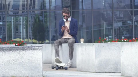 Stylish hipster with longboard using phone to make a call Stock Footage 132930733