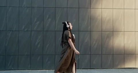 A Stylish Individual Strolling By Stunning Modern Architecture in an Urban City Stock Footage 301310250