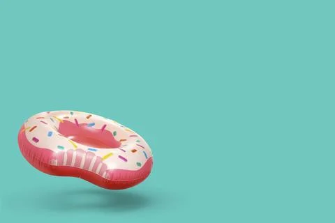 Stylish inflatable donut shaped ring in air on turquoise background. Space .. 스톡 사진