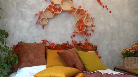 Stylish interior of room with big comfortable bed and autumn decor Stock Footage 234069025