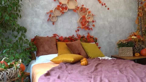 Stylish interior of room with big comfortable bed and autumn decor Stock Footage 234069028