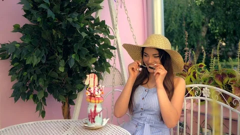 Stylish lady is spending her time in pink veranda drinking milkshake. Stock Footage 104057245