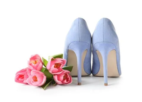 Stylish lady's shoes and beautiful spring tulips on white background. Interna Stock Photos