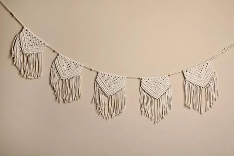 Stylish large macrame hanging on beige wall Stock Photos