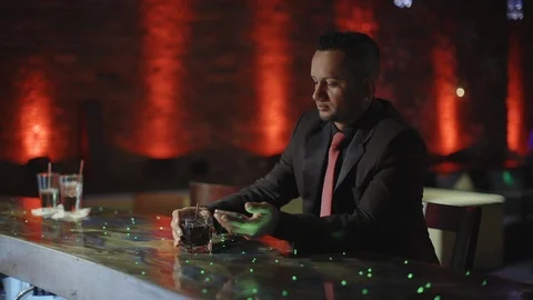 Stylish latin man sitting alone at bar counter with a whisky Stock-Footage 88158954