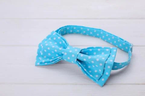 Stylish light blue bow tie with polka dot pattern on white wooden table, cl.. Stock Photos