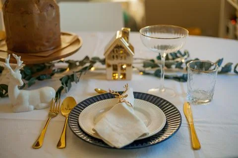 Stylish light Christmas table setting with golden cutlery. Festive feasts. .. Stock Photos