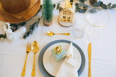 Stylish light Christmas table setting with golden cutlery. Festive feasts. De Stock Photos