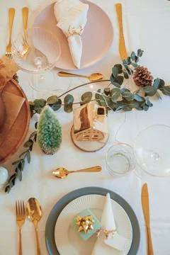 Stylish light Christmas table setting with golden cutlery. Festive feasts. De Stock Photos