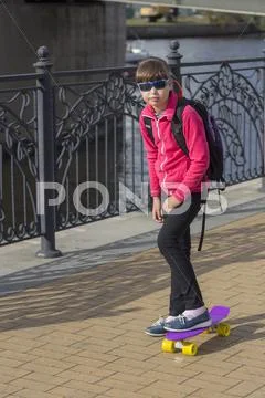 Stylish little girl child riding skateboard in city Stock Photos